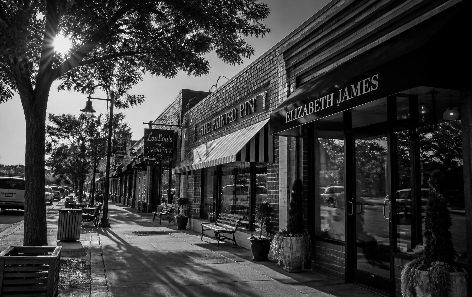Neighborhood main street with independent storefronts at golden hour